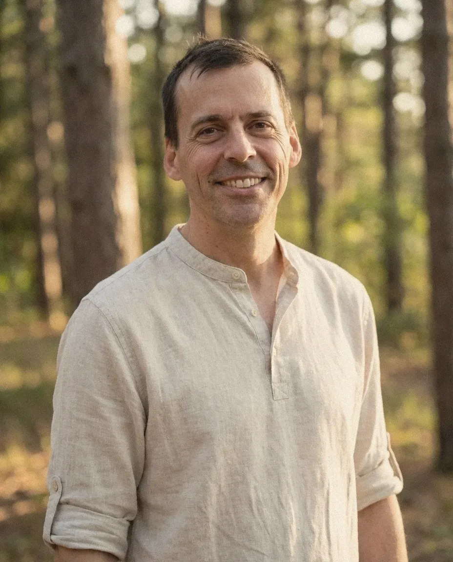 Julius Miribung im Wald, lächelnd, in hellem Leinenhemd